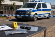 Police van behind cordon tape and secured evidence