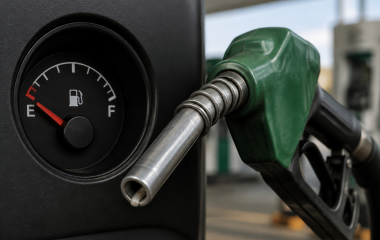 Generic fuel pump nozzle beside a nearly empty fuel gauge