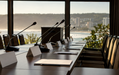 Empty conference table with microphones, blank name cards and a ballot box