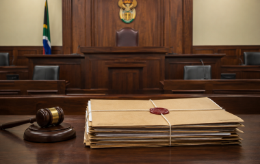 Empty courtroom with a sealed legal file on a wooden desk