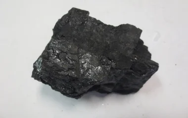 A bituminous coal sample on a pale background.
