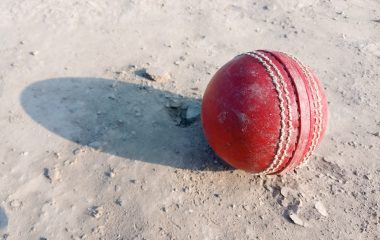Illustrative archive photograph of a red cricket ball on sandy ground