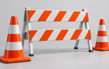 Conceptual studio illustration of traffic cones and a striped road barrier.